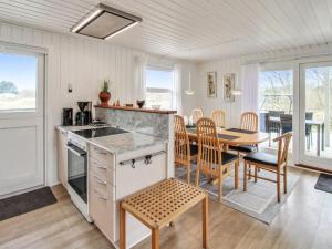 cocina y comedor con mesa y sillas en Holiday Home Bentine - 400m from the sea in Western Jutland by Interhome en Fanø