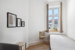 Habitación blanca con cama y ventana en Come Stay - 2BR Det perfekte hjem for 5, en Aalborg