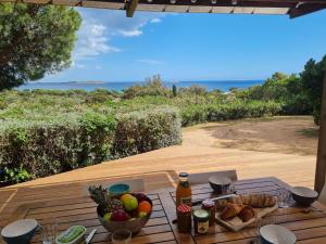 a table with a bowl of fruit on a deck at Holiday Home La Girelle by Interhome in Porto-Vecchio
