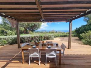 a wooden table and chairs on a wooden deck at Holiday Home La Girelle by Interhome in Porto-Vecchio