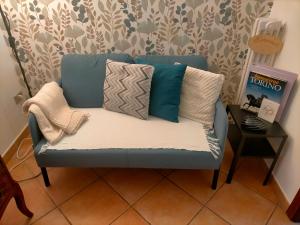 eine blaue Couch mit Kissen darauf in einem Zimmer in der Unterkunft Appartamento Pozzostrada in Turin