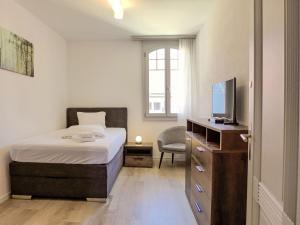 une chambre avec un lit, une télévision et une chaise dans l'établissement Apartment Henry's 300 by Interhome, à Interlaken 18 autres photos