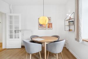 ein Esszimmer mit einem Holztisch und Stühlen in der Unterkunft Come Stay - 2BR Det perfekte hjem for 5 in Aalborg