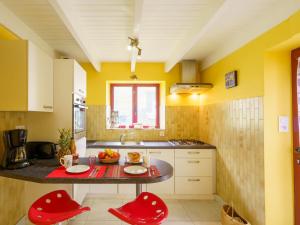 une cuisine avec une table et deux chaises rouges dans l'établissement Holiday Home Penty Landromiou by Interhome, à Crozon