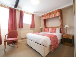 a bedroom with a large bed and a chair at The Speech House in Coleford