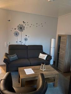 uma sala de estar com um sofá e uma mesa de centro em Ferienhaus Kalle 55180 em Detern