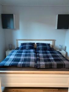 uma cama com duas almofadas em cima em Ferienhaus Kalle 55180 em Detern