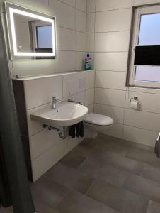 uma casa de banho com um lavatório e um WC em Ferienhaus Kalle 55180 em Detern