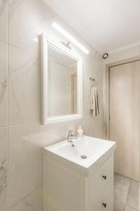a white bathroom with a sink and a shower at Varkiza Seaside 2BD Apartment in Varkiza