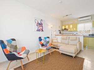 ein Wohnzimmer mit einem Sofa und Stühlen sowie eine Küche in der Unterkunft Holiday Home Las Mimosas by Interhome in Benitatxell