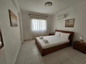 Un dormitorio con una cama grande y una ventana en Iris Village, en Pafos