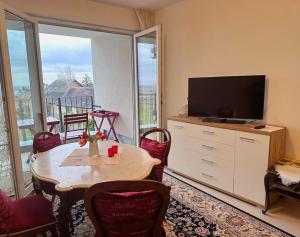 uma sala de estar com uma mesa e uma televisão em Ferienwohnung Casa del Vino em Neustadt an der Weinstraße