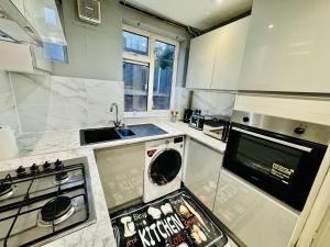 a kitchen with a sink and a stove top oven at 4-Bed Full House Stourbridge Birmingham in Stourbridge