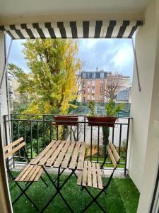 a balcony with a table and bench on a balcony at Appartement moderne Neuilly sur Seine au calme in Neuilly-sur-Seine