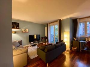 a living room with a couch and a table at Appartement moderne Neuilly sur Seine au calme in Neuilly-sur-Seine