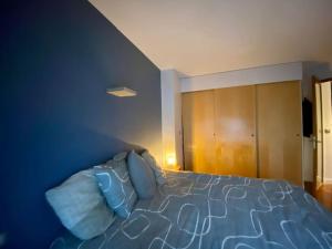 a bedroom with a bed and a blue wall at Appartement moderne Neuilly sur Seine au calme in Neuilly-sur-Seine