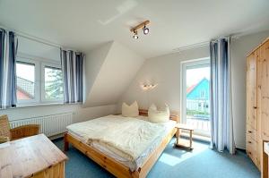 a bedroom with a bed and a table and windows at Luv in Zingst