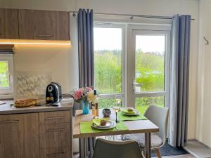 a kitchen with a table and a large window at Holiday Home Dahoam by Interhome in Wemding