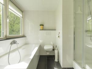 een badkamer met een bad, een toilet en een douche bij Holiday Home De Smokkelaar by Interhome in Simpelveld