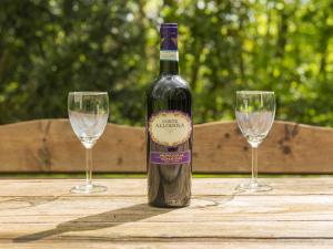 een fles wijn zittend op een tafel met twee glazen bij Holiday Home De Smokkelaar by Interhome in Simpelveld