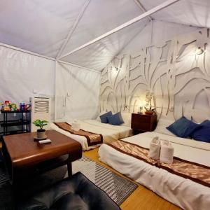 een kamer met drie bedden in een tent bij ไร่ภูพญา ม่อนแจ่ม เชียงใหม่ in Mon Jam