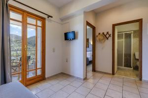 una camera da letto con porta che conduce a un balcone di Likasti a Skopelos Town