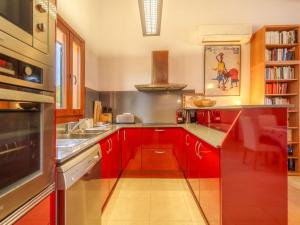 uma cozinha com armários vermelhos e um lavatório em Holiday Home Can Caragoli by Interhome em Alcudia