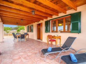a patio with chairs and a table and a wooden ceiling at Holiday Home Can Caragoli by Interhome in Alcudia