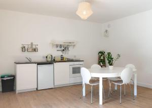 a white kitchen with a white table and chairs at Long Range 2, Henham Park Nr Southwold in Beccles