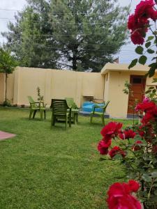 a yard with green chairs and a fence at Home Away From Home Cute 3 bedroom House G floor in Srinagar