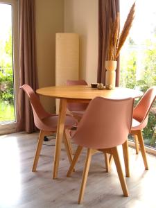 - une table à manger avec des chaises et une table en bois dans l'établissement Gezellig gemoderniseerd chalet op de Veluwe, à Putten