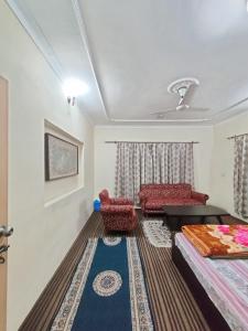 Habitación con cama, mesa y sillas. en Home Away From Home Cute 3 bedroom House G floor en Srinagar