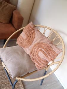 una coperta su una sedia di vimini in soggiorno di Gezellig gemoderniseerd chalet op de Veluwe a Putten