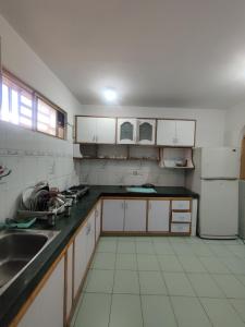 a kitchen with white cabinets and a sink at Home Away From Home Cute 3 bedroom House G floor in Srinagar