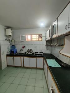 a kitchen with white cabinets and a black counter top at Home Away From Home Cute 3 bedroom House G floor in Srinagar