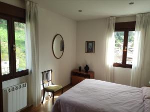 タソネスにあるApartamento Tazonesのベッドルーム1室(ベッド1台、椅子、窓付)