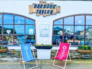 three signs in front of a harcourt tavern at Apartment Lighthouse View by Interhome in Mevagissey