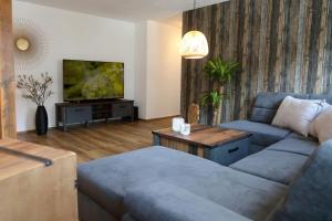 uma sala de estar com um sofá azul e uma televisão em Ferienwohnung Moselallee 5 Sterne em Moselkern