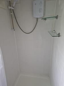a white bathroom with a shower with a toilet at The Cabin - a very quiet location in Pewsey +13 photos