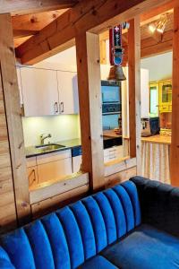 ein blaues Sofa in einem Zimmer mit Küche in der Unterkunft Apartment Chalet Bienli-2 by Interhome in Grindelwald
