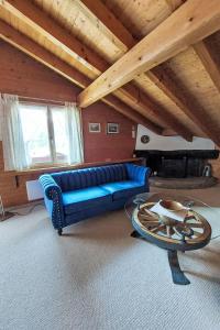 ein Wohnzimmer mit einem blauen Sofa und einem Tisch in der Unterkunft Apartment Chalet Bienli-2 by Interhome in Grindelwald