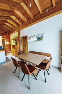 ein Esszimmer mit einem Holztisch und Stühlen in der Unterkunft Apartment Chalet Bienli-2 by Interhome in Grindelwald