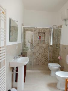 a bathroom with a shower and a sink and a toilet at Casa Locci in San Vito