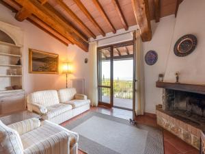 sala de estar con sofá y chimenea en Villa La Gattaiola by Interhome, en Montemerano