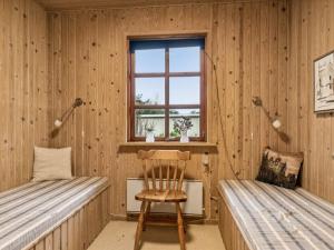 um quarto com duas camas e uma cadeira e uma janela em Holiday Home Niyazi - all inclusive - 770m from the sea by Interhome em Hals