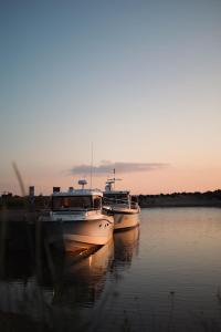 two boats are docked in the water at sunset at Beach & Golf Resort Marinan Kapteeni - sisältää loppusiivouksen in Kalajoki