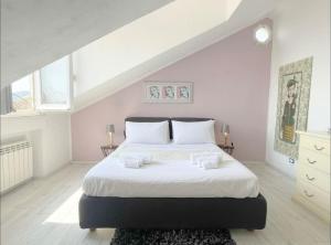 um quarto branco com uma cama grande e lençóis brancos em Mansarda Vista Mare a Zinola em Savona
