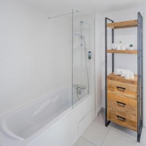 een badkamer met een douche en een houten dressoir bij All Suites Appart Hotel Le Havre in Le Havre