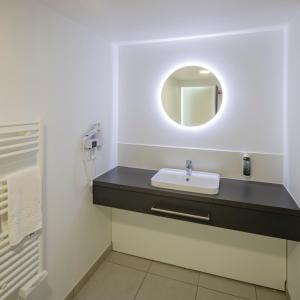 a bathroom with a sink and a mirror at All Suites Appart Hôtel - Le Havre Centre - Les docks in Le Havre