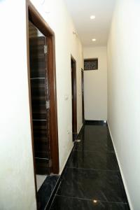 an empty hallway with doors and a tile floor at Pink City By Comfort Rooms in New Delhi